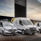 Zdjęcie z boku na samochody dostawcze przed budynkiem