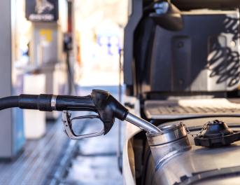 Dystrybutor paliwa wlewany do zbiornika pojazdu ciężarowego na stacji paliw.