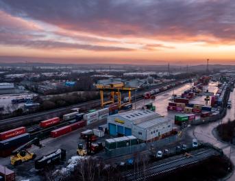 Zbliżenie na kontenery w porcie, gdzie odbywa się transport intermodalny.