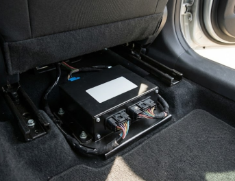 Czarna skrzynka w samochodzie pod fotelem pasażera.