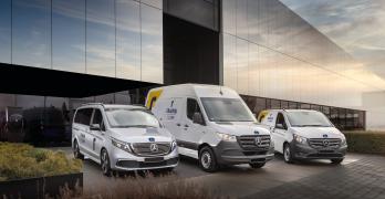 Zdjęcie z boku na samochody dostawcze przed budynkiem